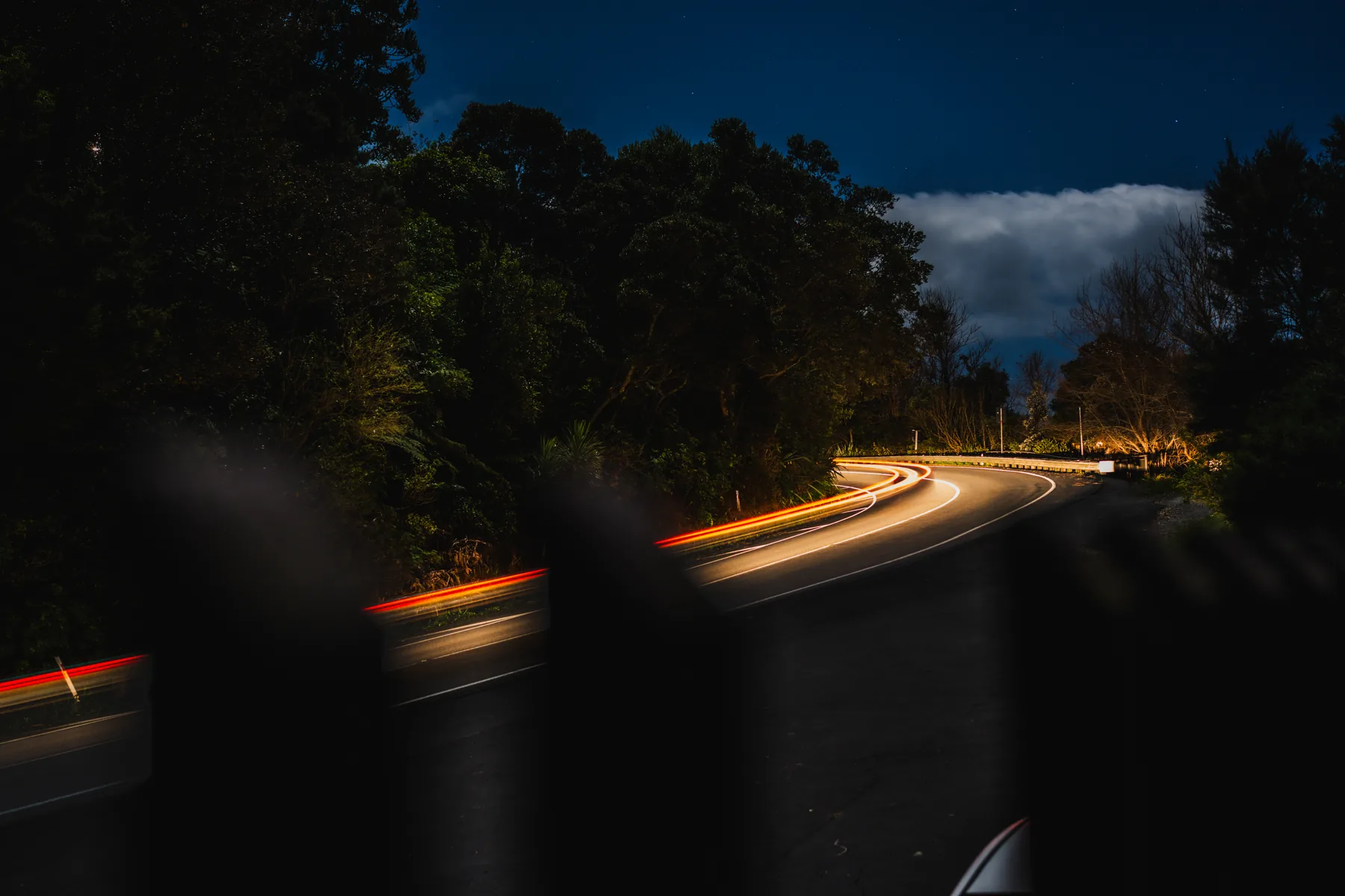 A road at night illuminated by flowing light trails
